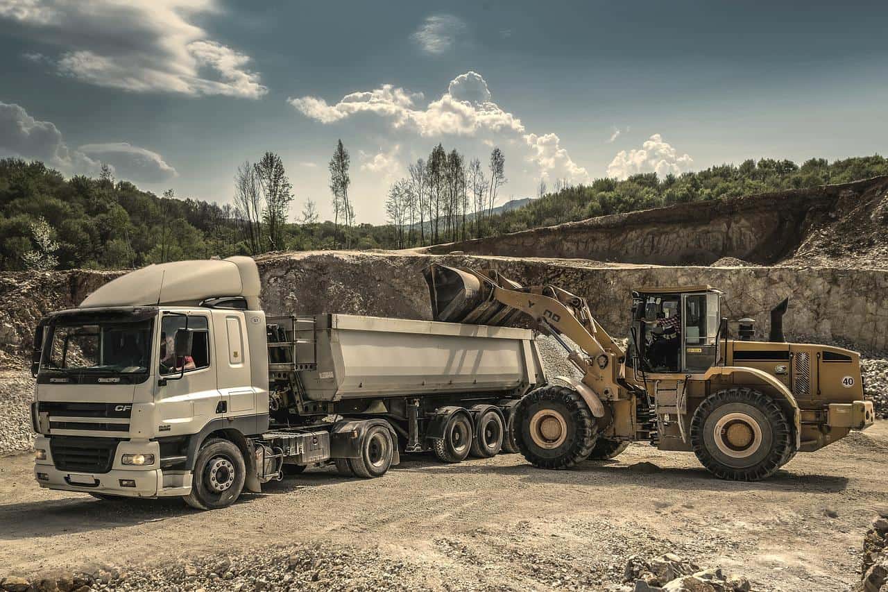 digger depositing contents into truck tray