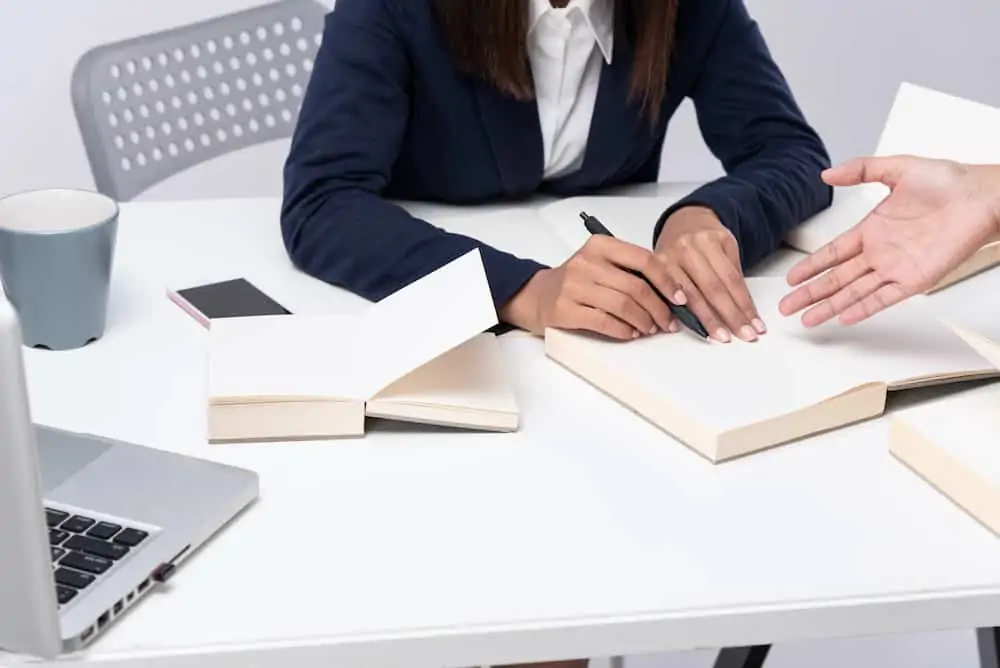 lawyer explaining something in a book to a client