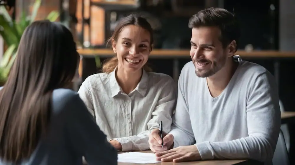 happy couple signing an insurance recovery claim