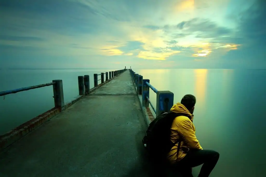 man sat on a pier staring at the view